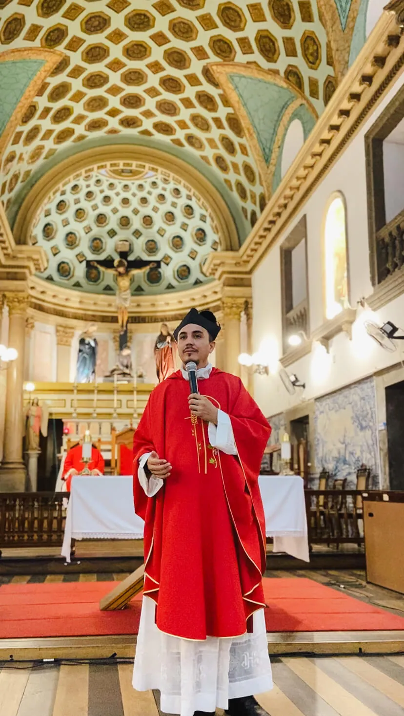 Padre de casula vermelha durante celebração em igreja histórica