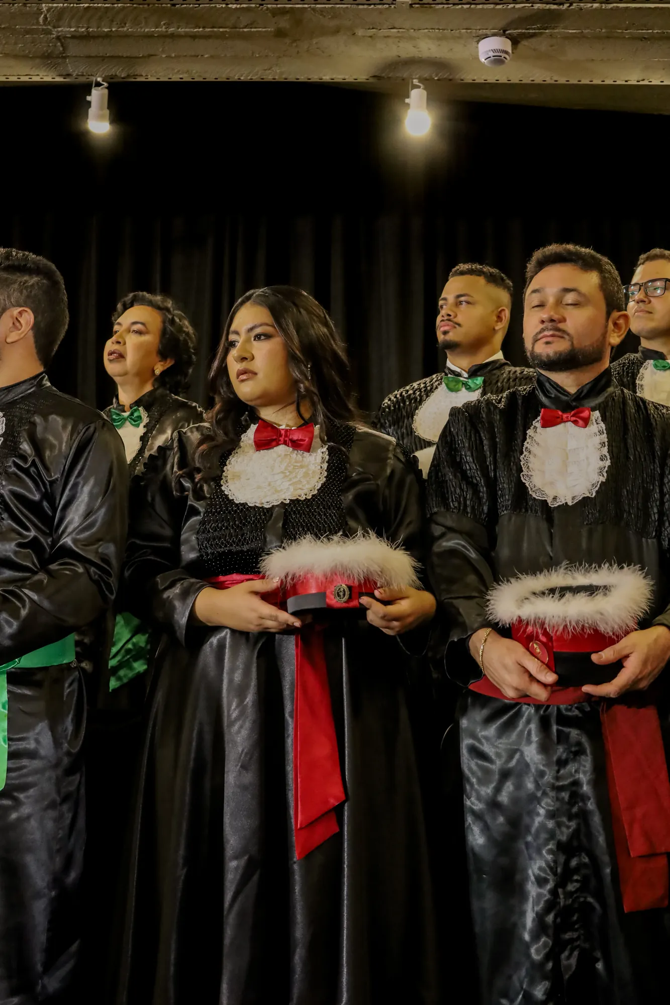 Turma de formandos de beca reunida no palco da colação de grau